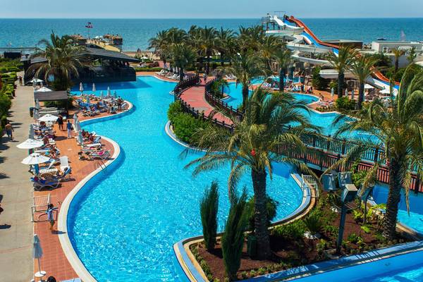 Luftaufnahme des Poolbereichs im Liberty Hotels Lara mit Wasserrutschen und Sonnenliegen.