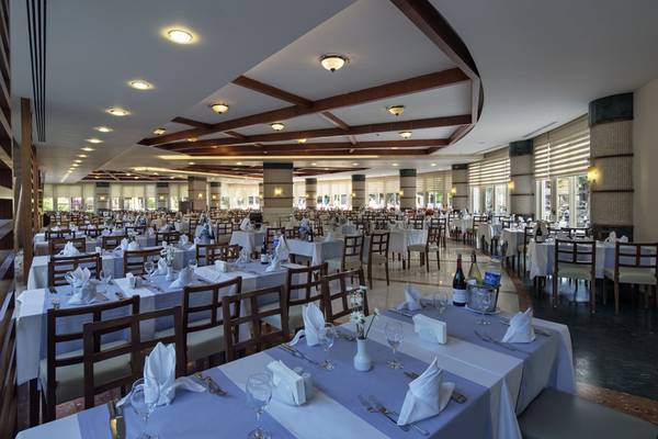 Innenansicht des Restaurants im Liberty Hotels Lara mit vielen gedeckten Tischen und Stühlen.