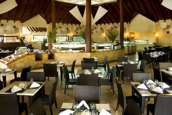 Innenansicht des Restaurants im IFA Villas Bavaro Hotel mit vielen Tischen und Stühlen, Buffet und hohen Decken.
