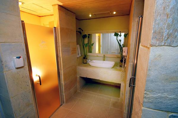 Badezimmer im IFA Villas Bavaro Hotel mit gelber Wand und braunen Fliesen.