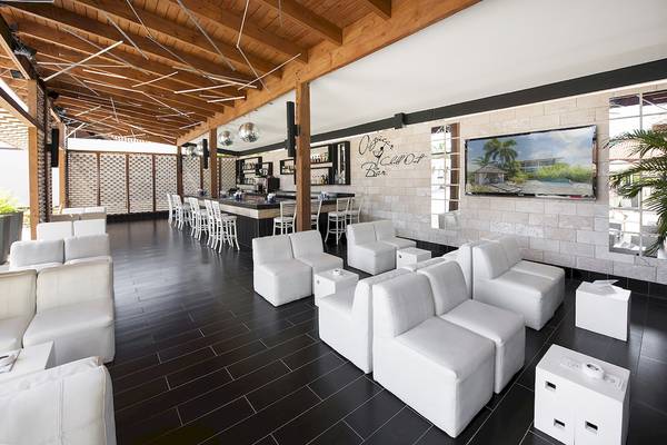 Lounge-Bereich im IFA Villas Bavaro Hotel mit weißen Möbeln und einer Bar.