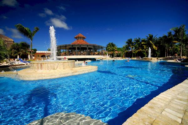 Außenpoolbereich des IFA Villas Bavaro Hotels mit blauem Wasser und Palmen