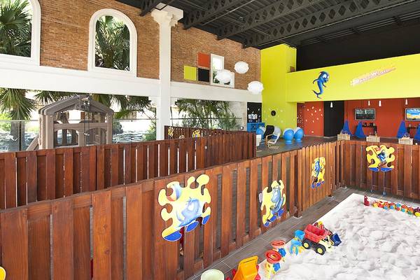 Innenansicht des Kinderbereichs im IFA Villas Bavaro Hotel mit Sandkasten, Spielzeug und bunten Wänden.