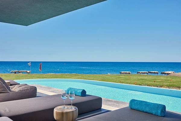 Aussicht von einem Pool des Atlantica Dreams Resorts mit Blick auf das Meer und Liegen.