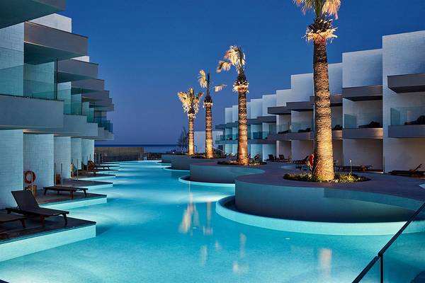 Außenpool des Atlantica Dreams Resorts bei Nacht mit mehreren Palmen und Sonnenliegen