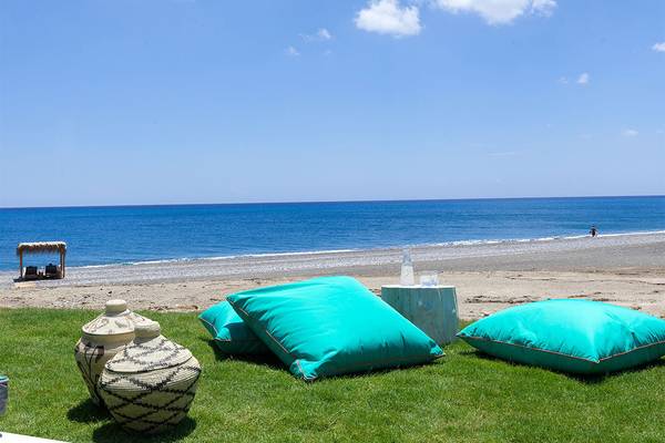 Strandloungebereich im Atlantica Dreams Resort mit Blick auf das Meer und türkisfarbenen Kissen.