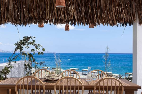 Terrasse mit Meerblick im Atlantica Dreams Resort mit braunen Strohdächern und blauem Himmel.