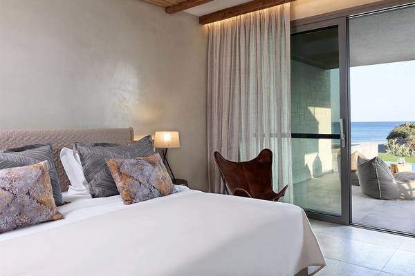 Schlafzimmer des Atlantica Dreams Resorts mit Blick auf das Meer, großem Bett und Terrassentür.