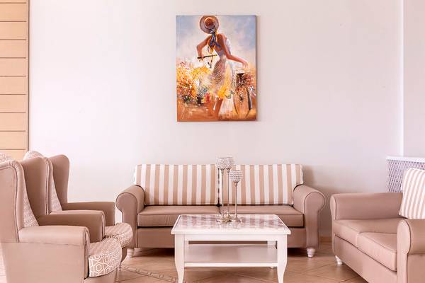 Wohnzimmer im Civitel Creta Beach Hotel mit Sofas, Stühlen und einer Wandmalerei.