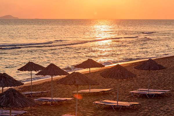 Sonnenuntergang am Civitel Creta Beach mit Strand, Sonnenschirmen und Liegestühlen