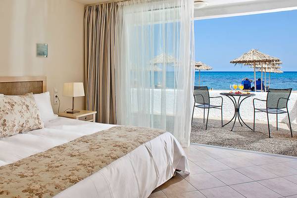 Zimmer mit Meerblick im Civitel Creta Beach Hotel mit Balkon, Tisch und Stühlen.