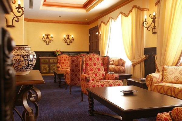 Hotellobby der Europe Villa Cortes mit dekorativ eingerichteten Sitzbereichen, Vasen und Wandleuchten.