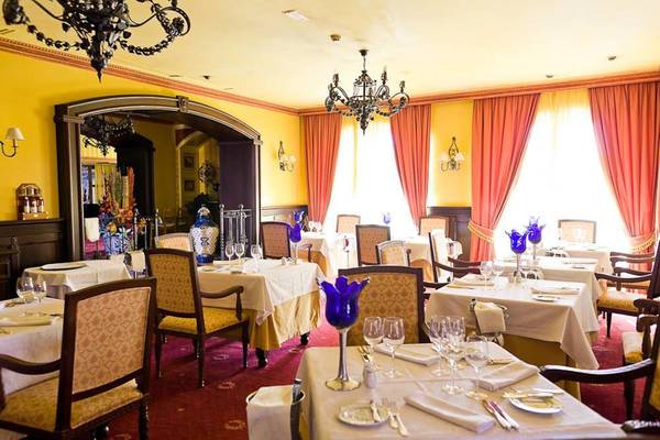 Innenbereich des Restaurants im Hotel Europe Villa Cortes mit gedeckten Tischen und gelben Wänden.