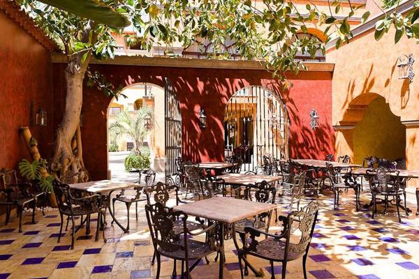 Gartenrestaurant der Europe Villa Cortes mit bunten Fliesen und rustikalen Möbeln.