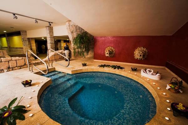 Innenpool im Hotel Europa Villa Cortes mit roten Wänden und stilvollen Dekorationen.