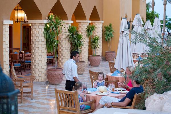 Familie isst im Freien auf der Terrasse des Grand Waterworld Makadi Hotels