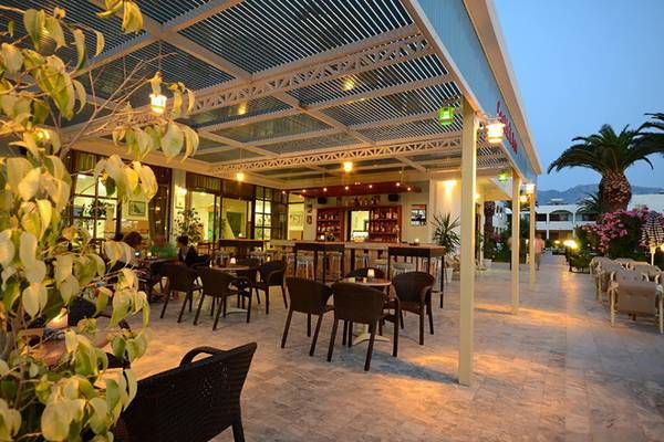 Abendliche Außenterrasse des Tropical Sol Hotels mit beleuchteten Tischen und Stühlen.