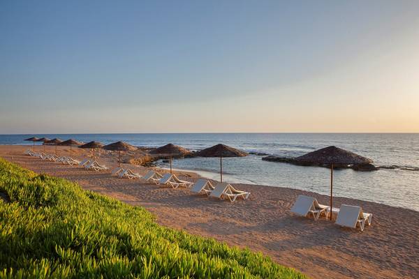 Strand des Louis Imperial Beach Hotels mit Sonnenliegen und Sonnenschirmen am Meer