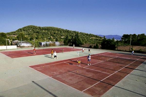 Tennisplatz im Freien beim Marble Stella Maris Ibiza mit Spielern und gelben Bällen.