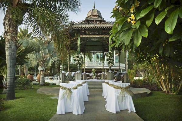 Hochzeitspavillon im Jardines de Nivaria Hotelgarten mit weißen Stühlen und Blumendekoration.