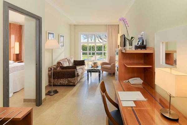 Innenansicht eines Hotelzimmers im Jardines de Nivaria mit Wohnzimmermöbeln und Schreibtisch.