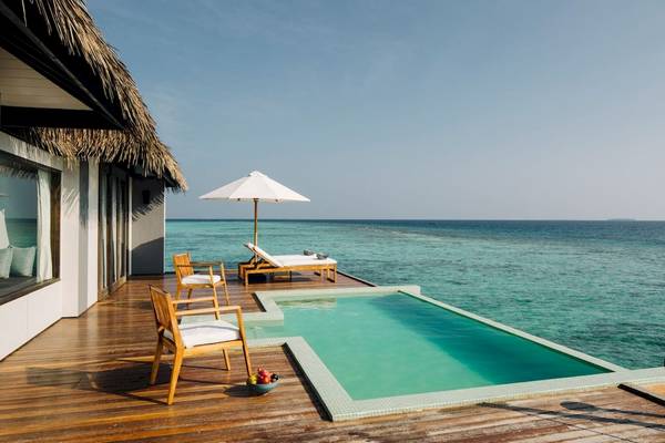Terrasse des Noku Maldives Hotels mit Pool und Blick auf das Meer