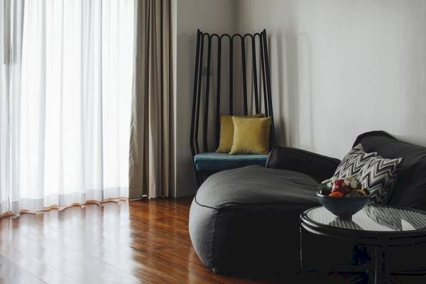 Wohnzimmer des Noku Maldives Hotels mit einem großen grauen Sitzsack und einem Tisch mit Obst.