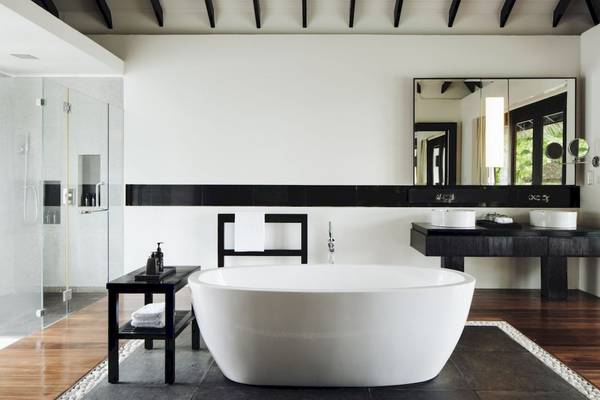 Luxus Badezimmer im Noku Maldives mit Badewanne, Waschbecken und Glasdusche