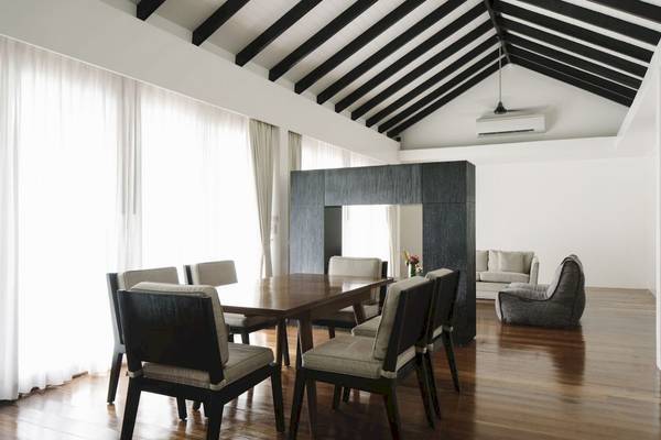 Innenansicht des Speisezimmers im Noku Maldives Hotel mit Holzboden, weißen Wänden und Möbeln.