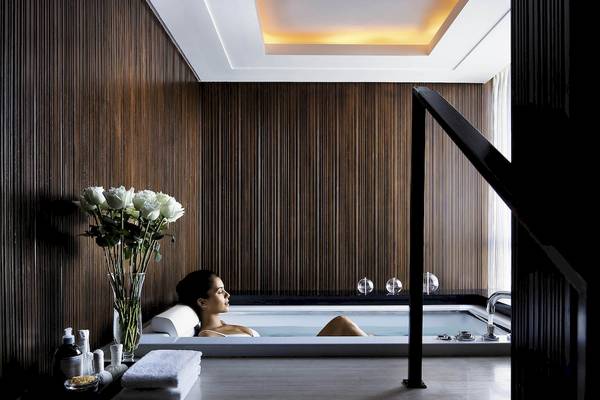 Eine Frau entspannt sich in der Badewanne im Sofitel Bangkok Sukhumvit.