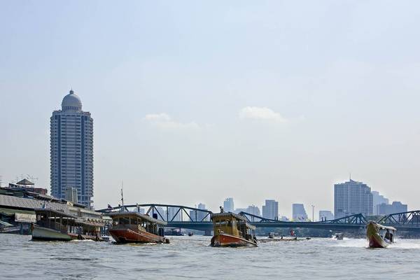 Boote auf dem Wasserweg mit einem großen Hochhaus im Hintergrund.