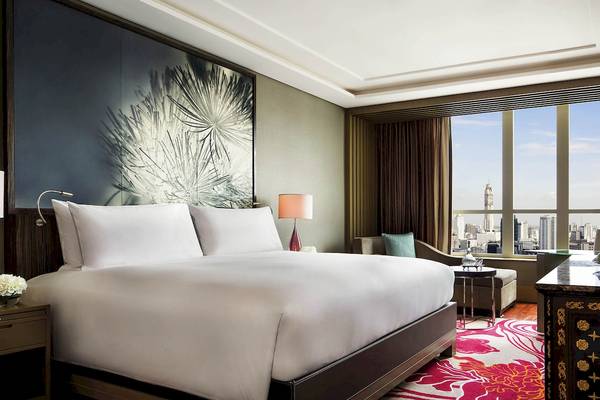 Schlafzimmer im Sofitel Bangkok Sukhumvit Hotel mit Blick auf die Stadt.