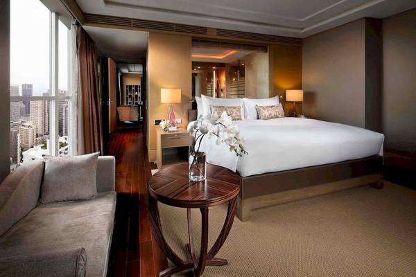 Ein elegantes Zimmer im Sofitel Bangkok Sukhumvit Hotel mit einem großen Bett, Stadtblick und modernen Möbeln.