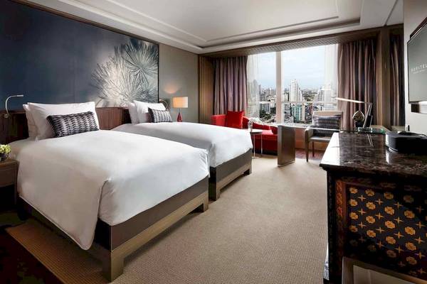 Doppelzimmer im Sofitel Bangkok Sukhumvit mit zwei Betten, Schreibtisch, Stadtblick und modernen Möbeln.