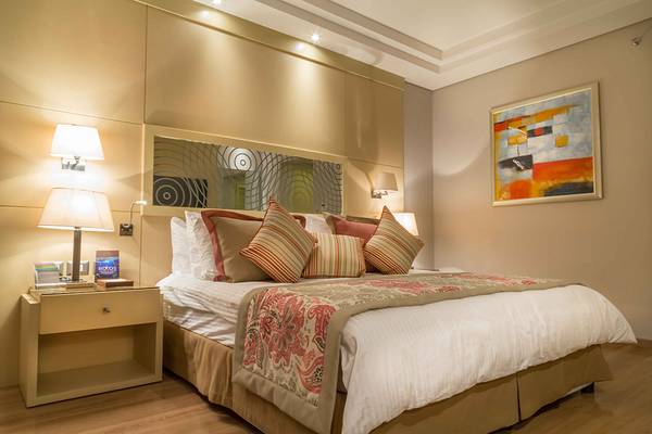 Ein Hotelzimmer im Rixos Premium Seagate mit einem Doppelbett, Nachttischen und Kunstwerken an der Wand.
