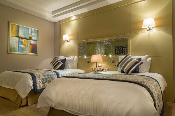 Doppelbett-Zimmer im Rixos Premium Seagate Hotel mit zwei Betten, Dekor und Lampen.