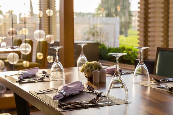 Tisch im Rixos Premium Seagate mit Geschirr und Blumen auf der Tischdecke.