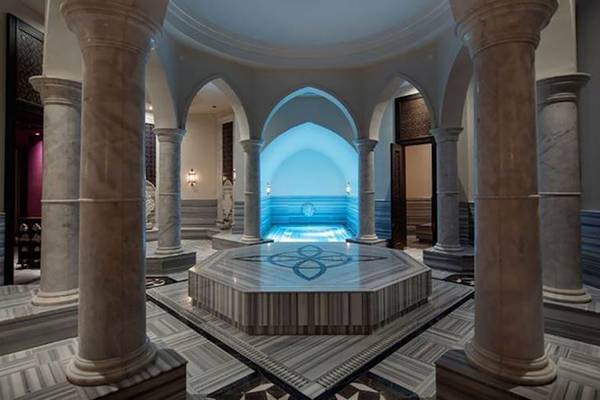 Innenbereich des Rixos Premium Seagate mit Marmorsäulen und einem zentralen Pool.