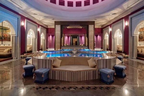 Innenansicht des Rixos Premium Seagate Hotel-Loungebereichs mit einem zentralen Wasserbecken und bequemen Sitzgelegenheiten.
