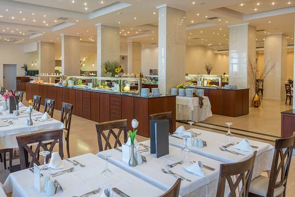 Restaurant im Kresten Palace Hotel mit langen Tischen, Stühlen und einer langen Buffettheke.