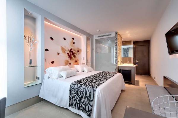 Hotelzimmer im Barcelo Illetas Albatros Hotel mit weißem Bett, Blumenwand und Fernseher