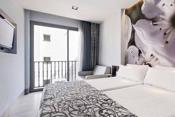 Hotelzimmer mit zwei Betten, Balkon, Sessel und Fernseher