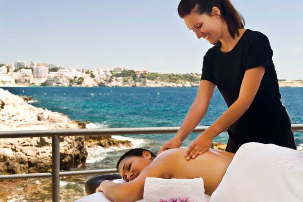 Eine Frau genießt eine Massage am Strand im Barcelo Illetas Albatros Hotel.
