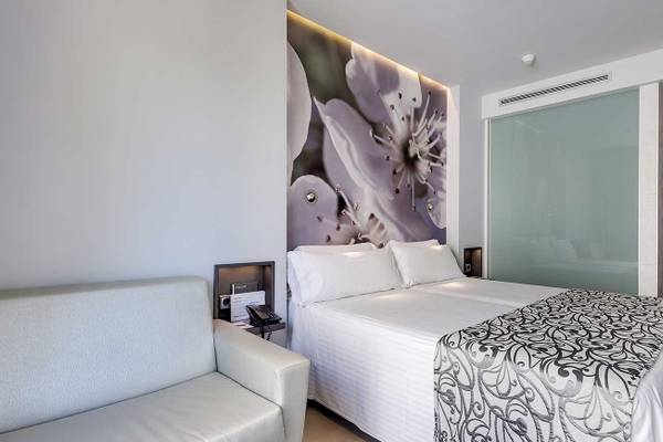 Hotelzimmer im Barcelo Illetas Albatros Hotel mit Doppelbett, Couch und Kunstwand