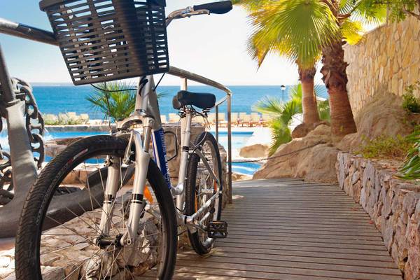 Fahrrad mit Korb am Rand des Swimmingpools im Barcelo Illetas Albatros Hotel.