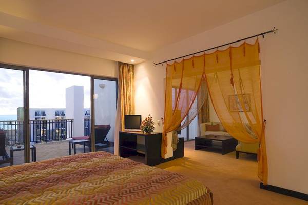 Hotelzimmer im Royal Atlas & Spa mit Blick auf die Stadt und Balkon.