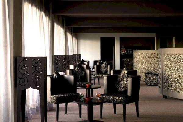 Loungebereich des Royal Atlas & Spa Hotels mit schwarzen Möbeln und goldenen Akzenten.