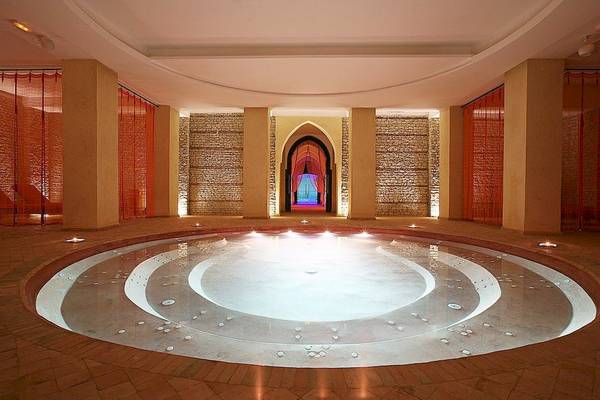 Innenansicht des Pools im Royal Atlas & Spa Hotel, mit Wasser und Leuchten.