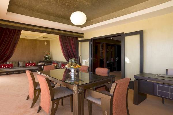 Speisezimmer im Royal Atlas & Spa mit Tisch, Stühlen und Dekor.