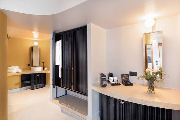Das Badezimmer des Ikaros Beach Luxury Resort & Spa mit einem Waschbecken, einem Spiegel und einer Dusche.